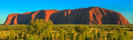 Banner panorama of huge Ayers Rock monolith from Talinguru Nyakunytjaku sunrise viewing area in Uluru-Kata Tjuta National Park, Australia, Northern Territory. Aboriginal land in Australian Red Centre.